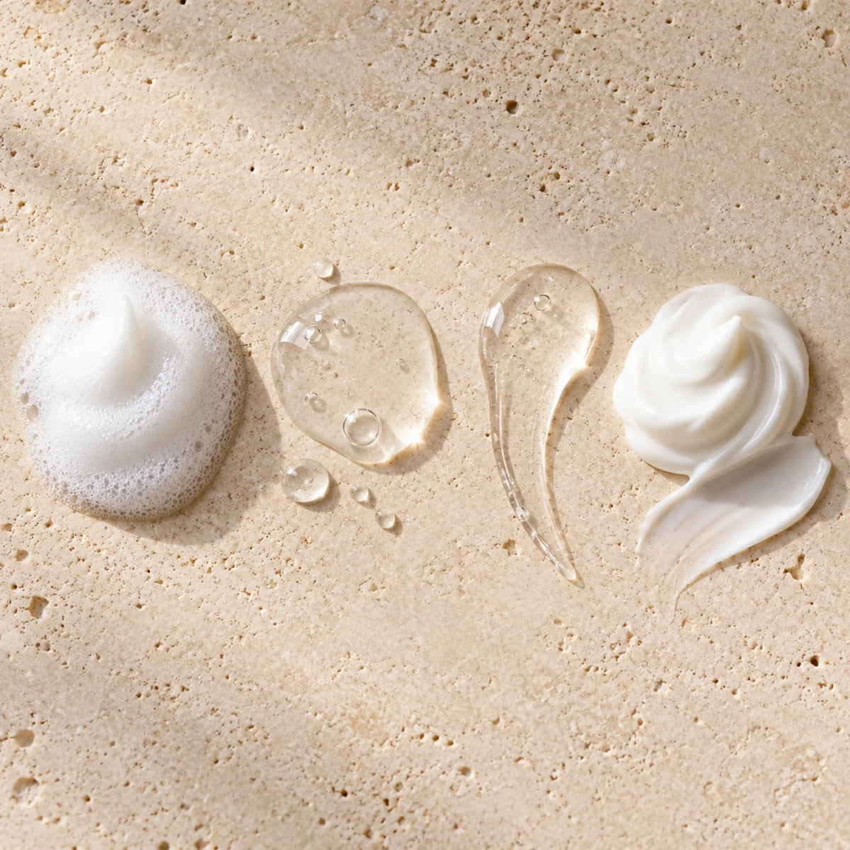Quattro texture Curamour: mousse bianca, tonico e siero trasparenti e crema bianca