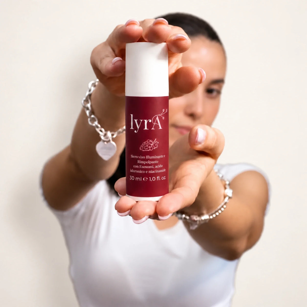 Donna che mostra il flacone del siero viso lyrA in primo piano