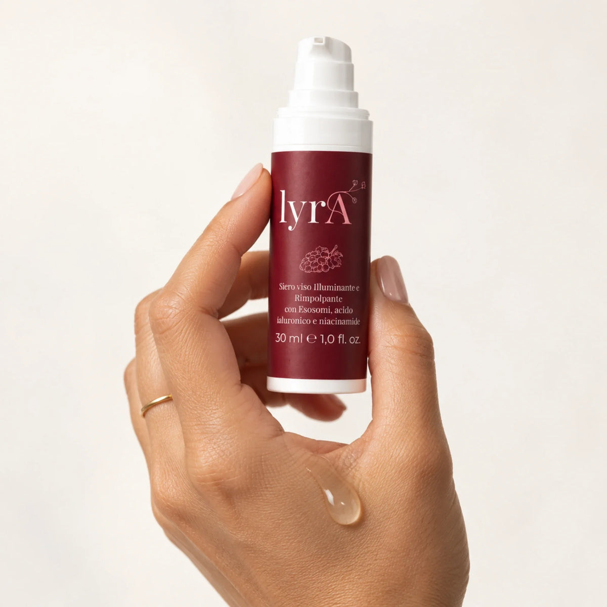 Mano che tiene il flacone del siero viso lyrA Curamour