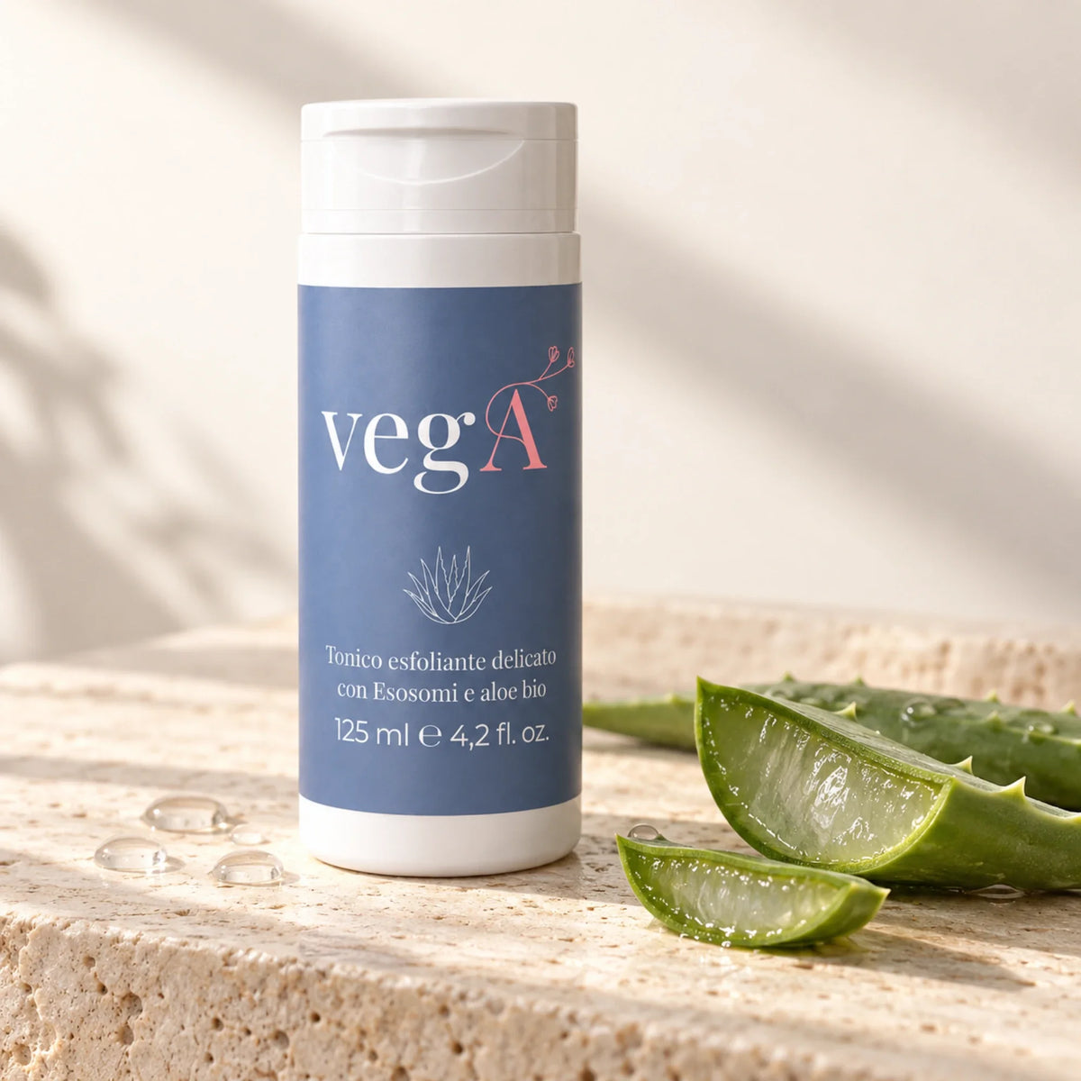 Tonico esfoliante vegA su travertino accanto a foglie di aloe vera