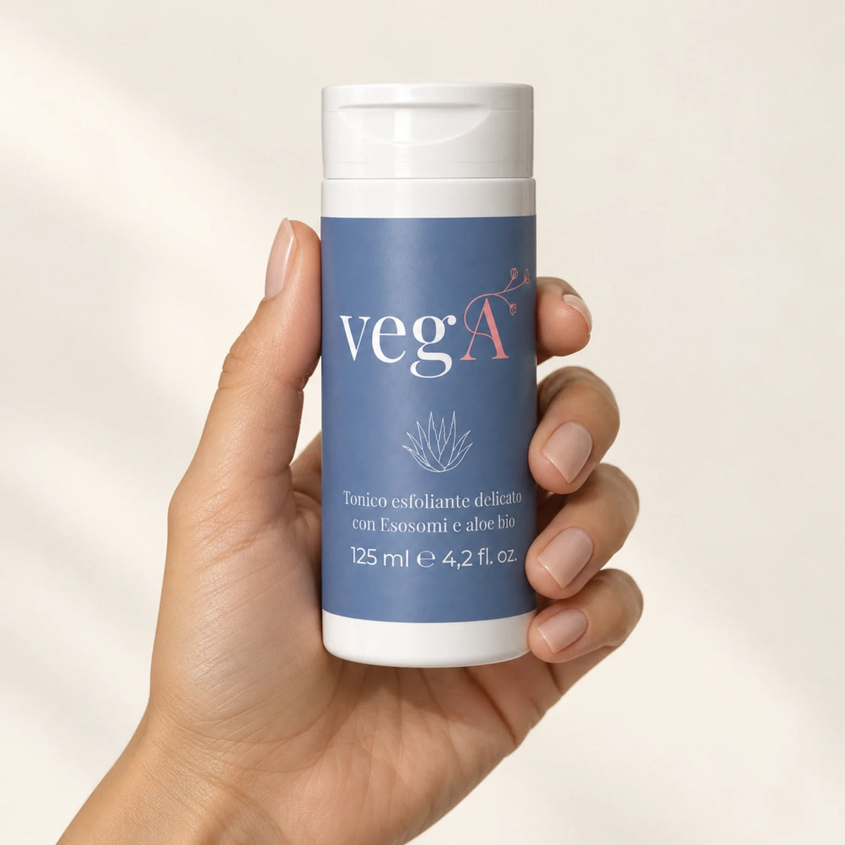 Mano che tiene il flacone del tonico esfoliante vegA Curamour